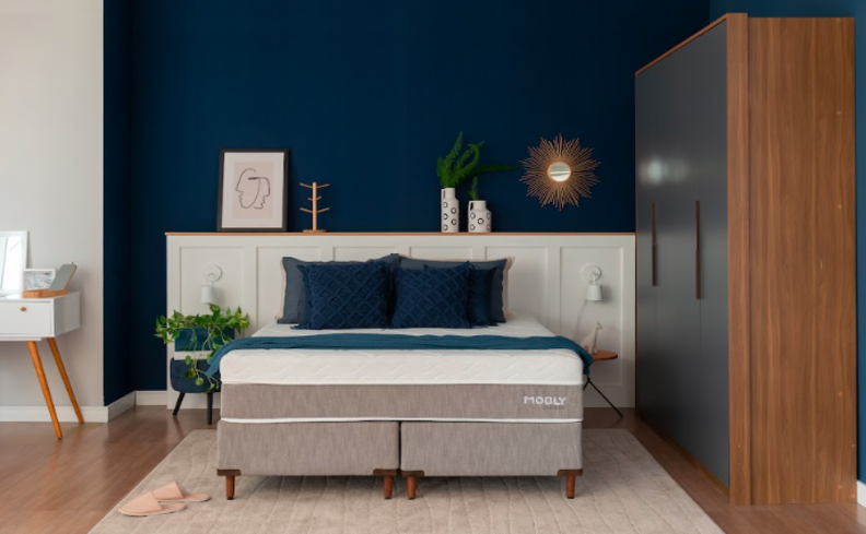 tamanho de colchão em um quarto com cama box de casa, travesseiros e diversos itens decorativos.