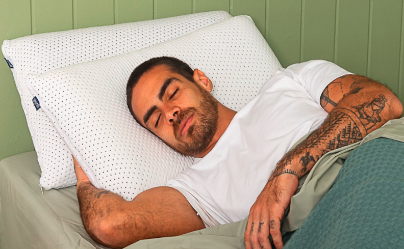 pessoa deitada na cama com dois travesseiros e coberto com um sono confortável e saudável