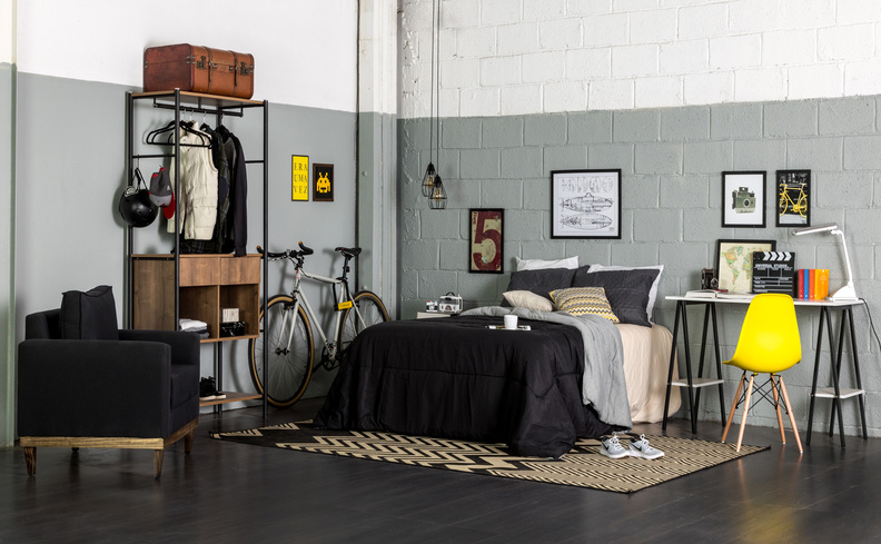 colchão de casal para cama box em um quarto casal completo com cama, tapete, mesa de cabeceira, bicicleta e arara de roupas