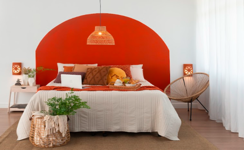 bases de cama de casal em um quarto com cama, travesseiros, almofadas com roupa de cama branca e laranja