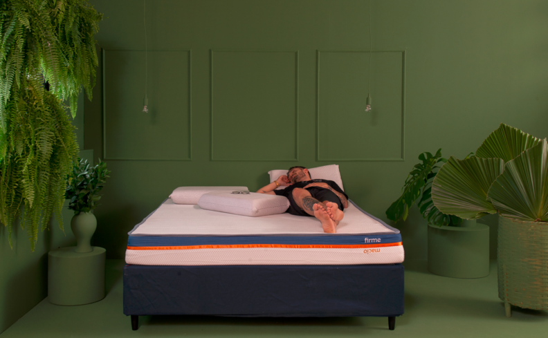 tipos de colchão de espuma tamanho casal, em um ambiente com parede verde e diversas plantas de decoração