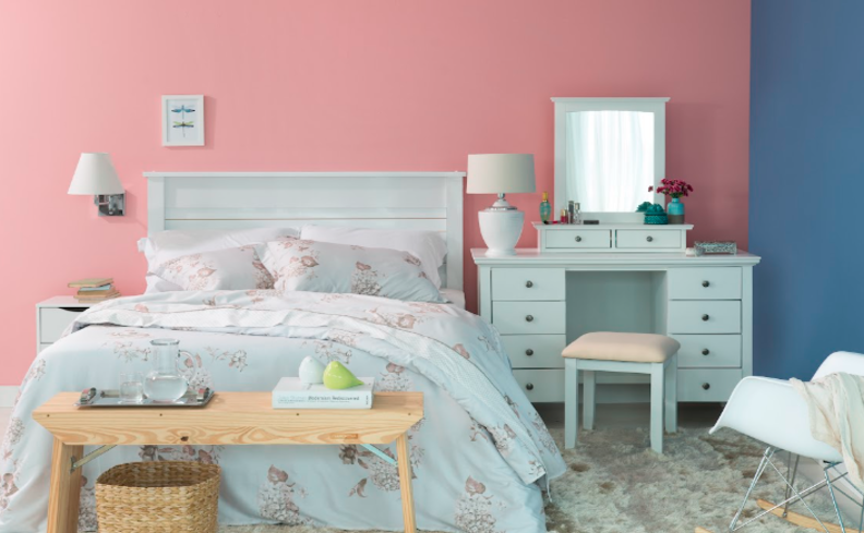 cromoterapia das cores em um quarto com parede rosa e roupa de cama azul claro para proporcionar diversos benefícios