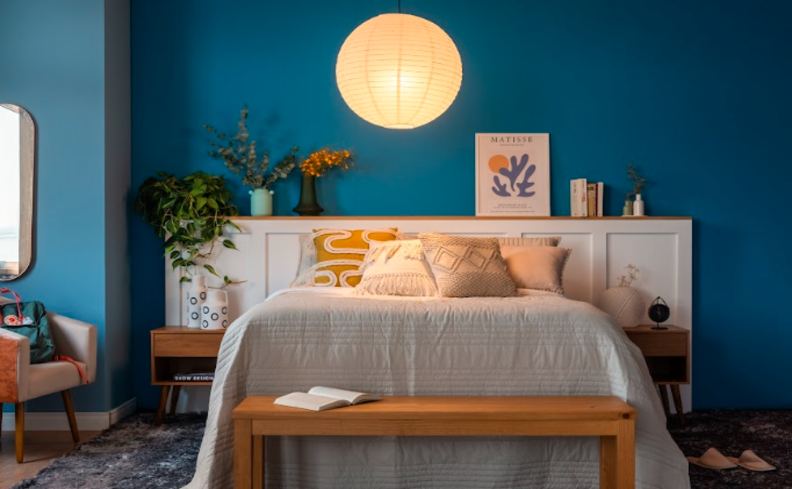 dicas para dormir bem em um quarto confortável com cama, travesseiros, iluminação suave e itens decorativos