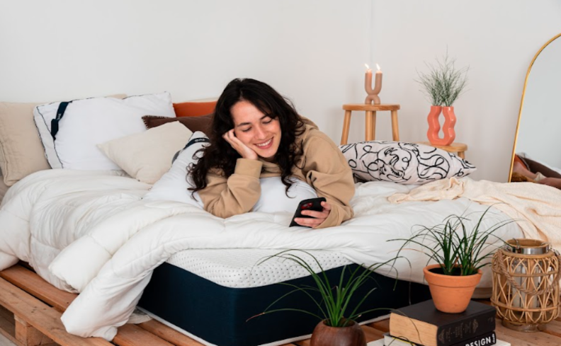 qual a importância do sono com uma pessoa deitada na cama mexendo no celular