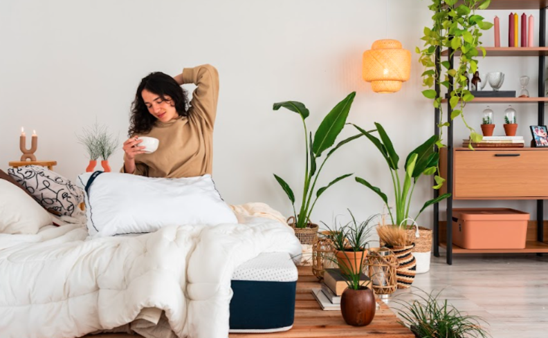 o que é ciclo circadiano e como ele pode afetar a saúde, com uma mulher sentada na cama se espreguiçando