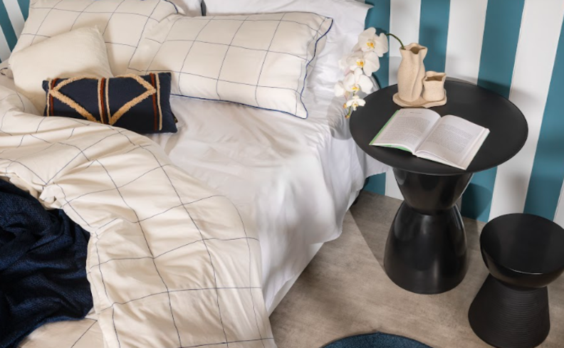 ciclo circadiano e o que é, um quarto com cama e roupas de cama, além de travesseiros, mesa de cabeceira e itens decorativos.