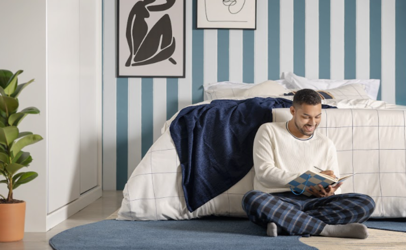 homem em um quarto sentado no chão procurando saber o que é o distúrbio do sono e os sintomas.