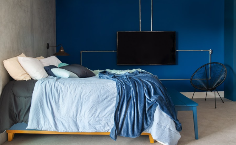 quarto de casal bagunçado com cama, roupas de cama, almofadas e travesseiros.
