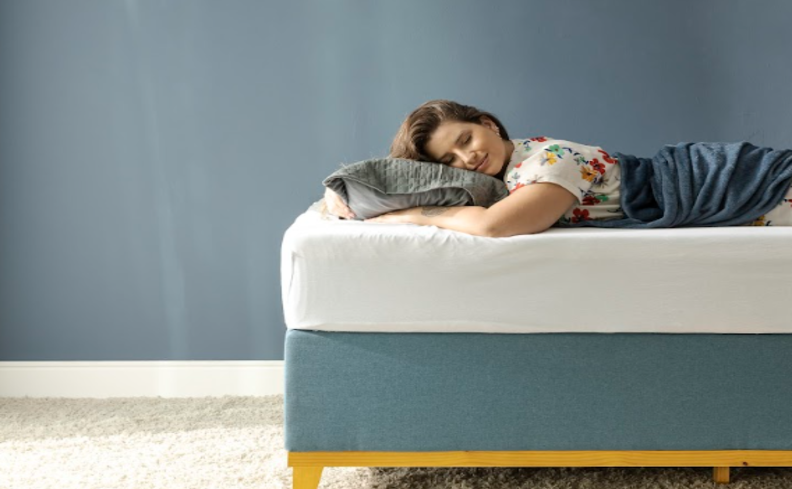 o que é paralisia do sono, com uma mulher deitada na cama usando travesseiro e cobertor.