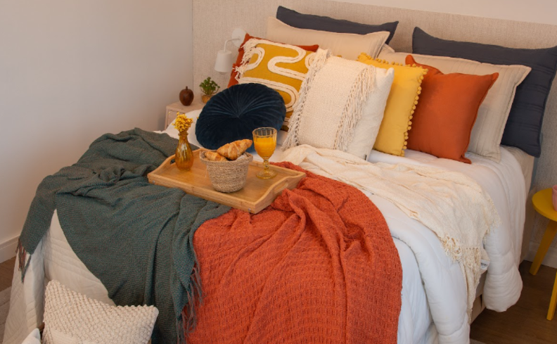 quarto com cama, almofadas e diversas mantas, além de uma bandeja com alimentos leves para saber o que comer antes de dormir
