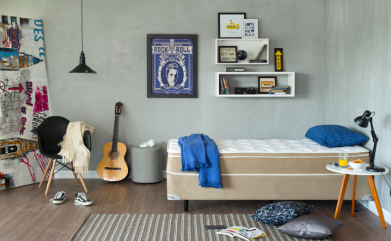 como tirar ácaro do colchão e travesseiro em um quarto com cama, travesseiro, manta, quadros, prateleiras, nichos e diversos itens de decoração.