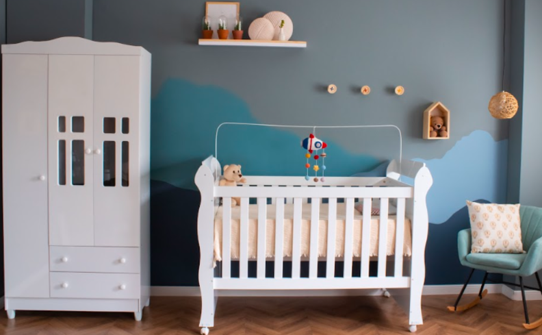 colchão de solteiro em um quarto de bebê com berço, guarda-roupa, poltrona e diversos itens decorativos.