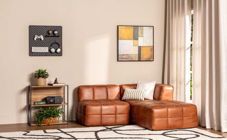 sofás compactos em módulos na cor marrom, além de tapete, mesa de apoio de madeira, quadro decorativo e cortinas.